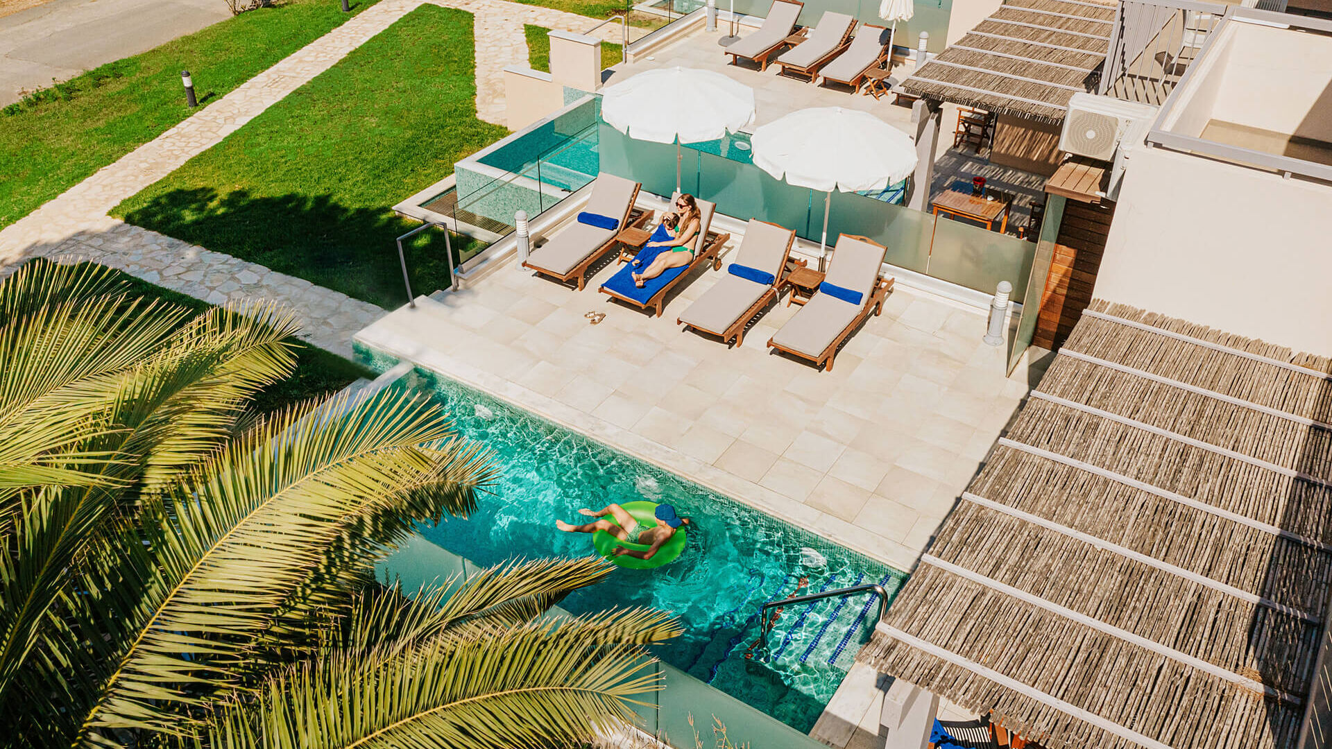 Mother and children at private pool outside suite at Louis St. Elias