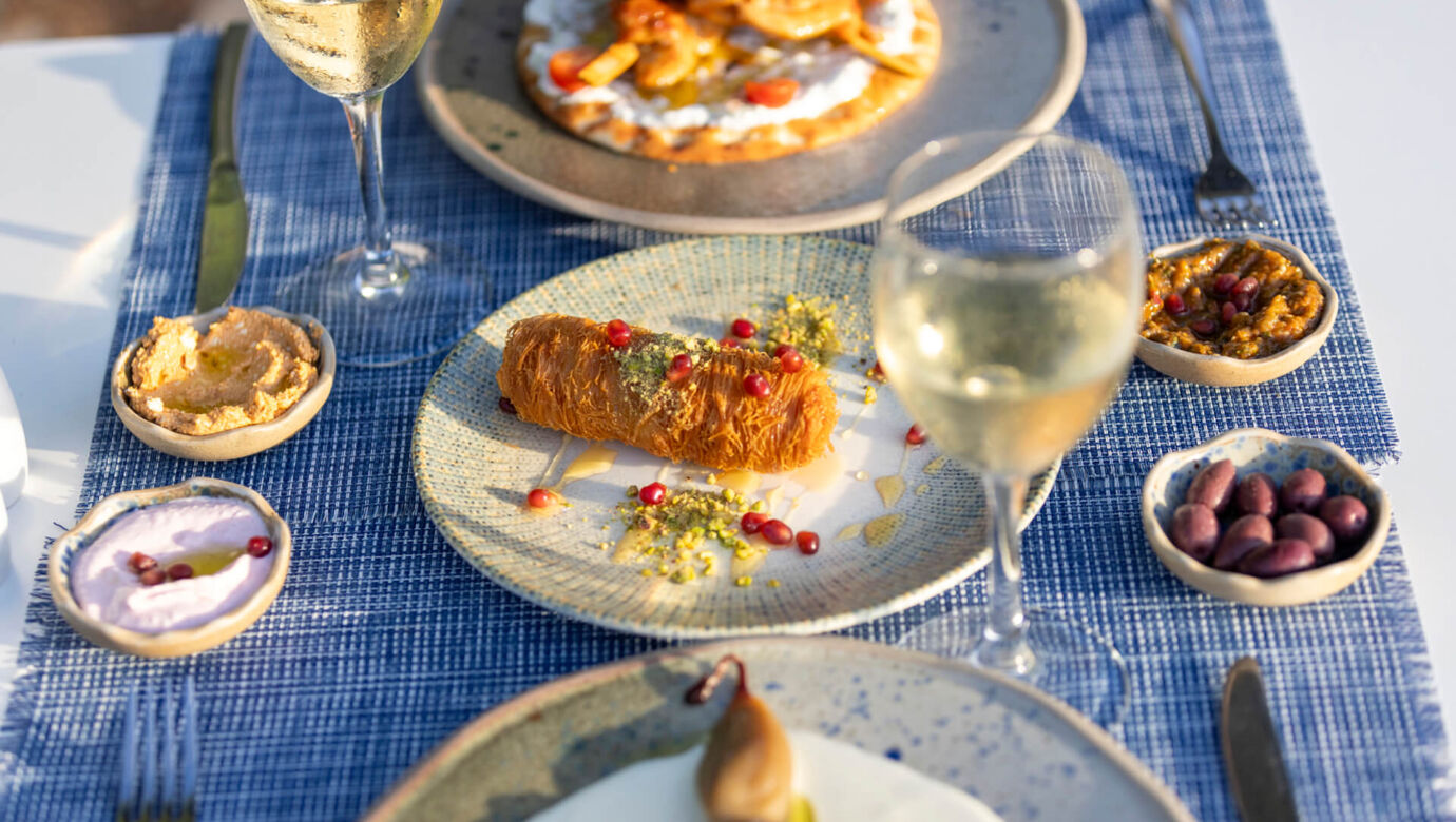 Table with traditional food , spreads and wine at Louis St, Elias Meze restaurant