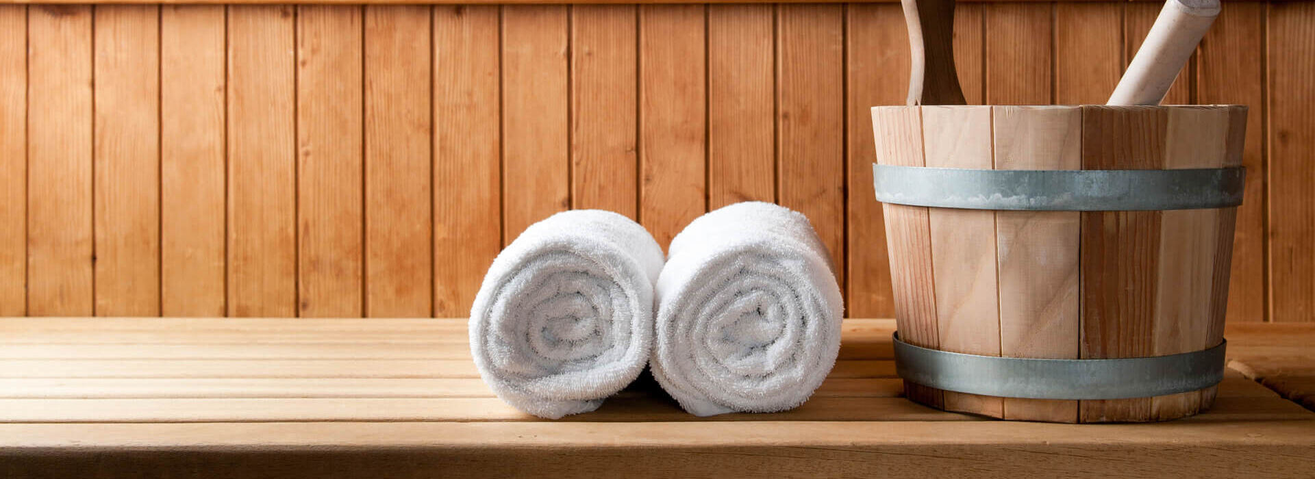 Towels and water bucket inside sauna at Louis St. Elias Spa