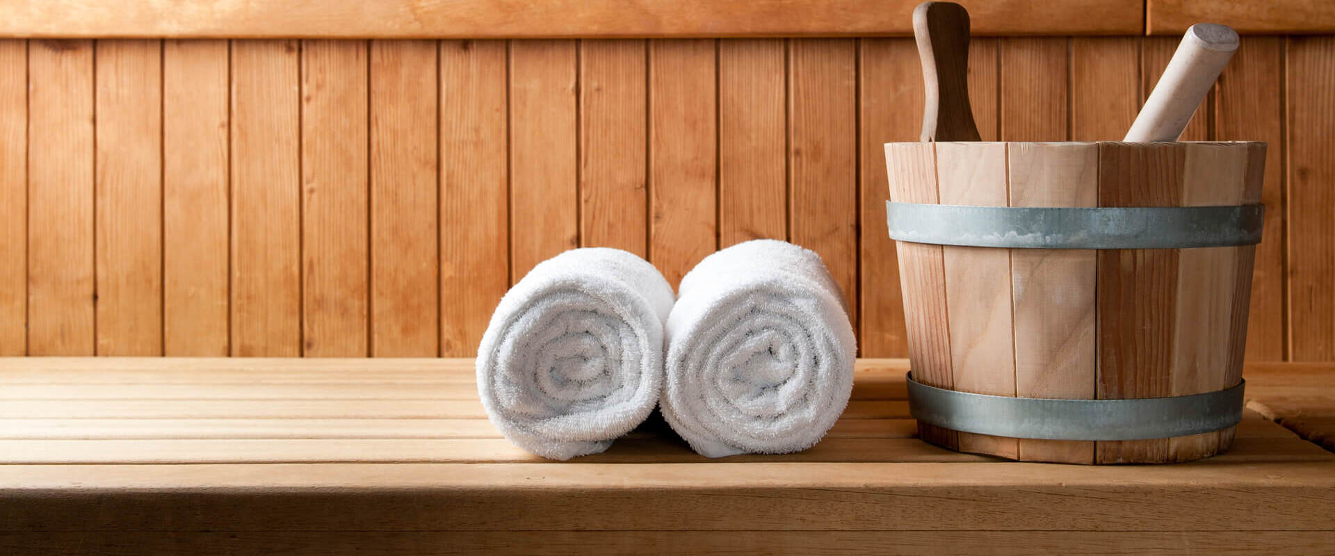 Towels and water bucket inside sauna at Louis St. Elias Spa