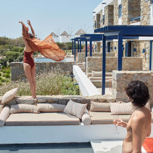 Man watching a woman on top of a rock ledge