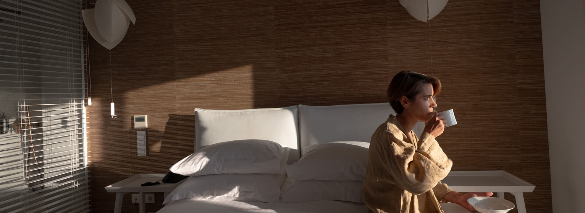 Woman relaxing on the bed at Once In Mykonos room