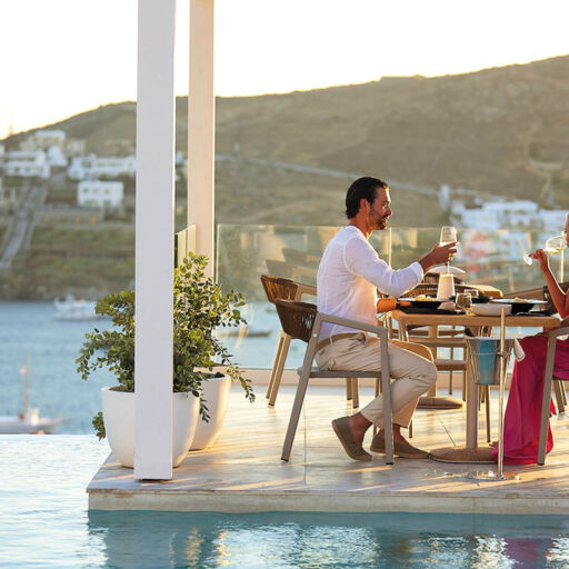 Couple drinking and eating poolside at Once In Mykonos