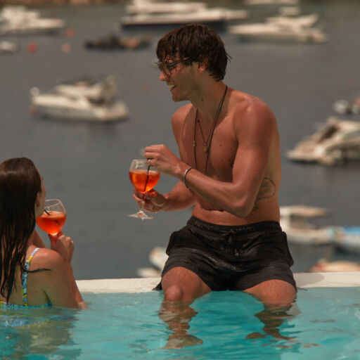 Couple drinking cocktails while taking a swim at the pool of Once in Mykonos