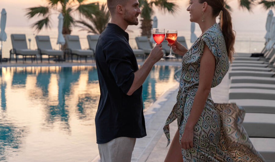 Couple drinking wine pool side