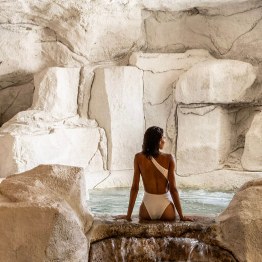 Woman sitting beside an indoor cave pool at Cali Resort & Spa