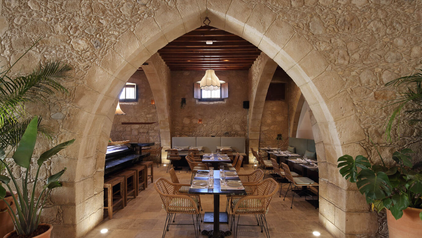 Indoor stone arch and tables prepared for lunch at Polis 1907