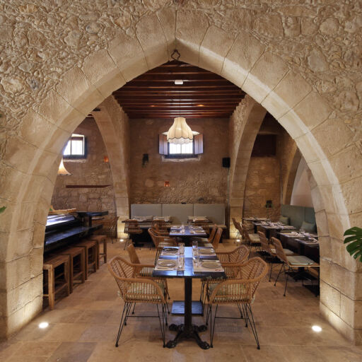 Indoor stone arch and tables prepared for lunch at Polis 1907
