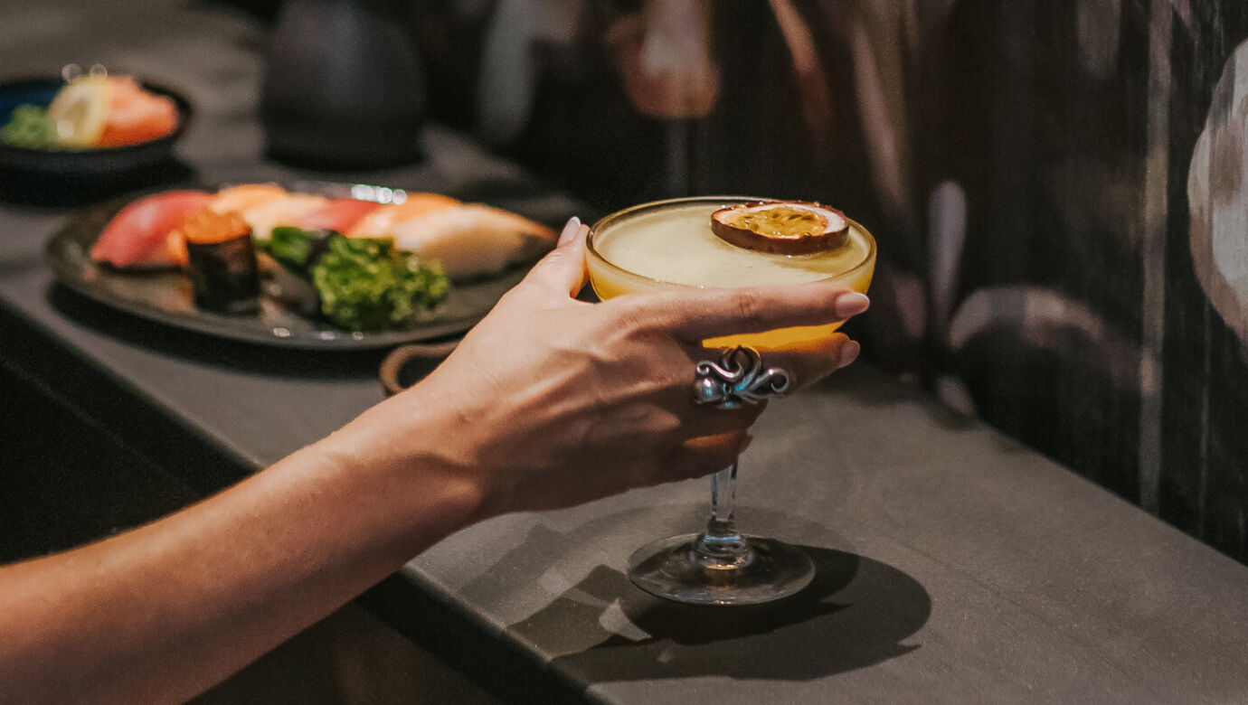 Woman having a cocktail sushi at Royal Apollonia Akakiko restaurant