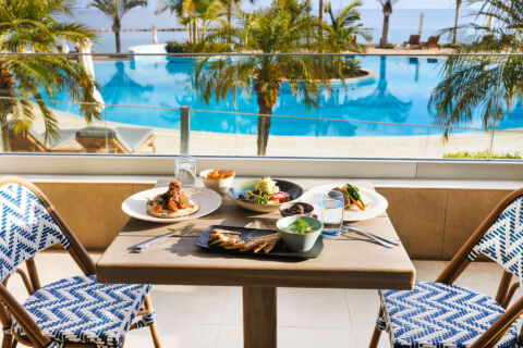 Table with food at Royal Apollonia Alati restaurant with pool view