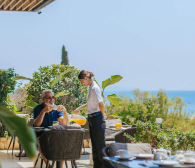 Man getting served orange juice at Royal Apollonia Aura restaurant outside table