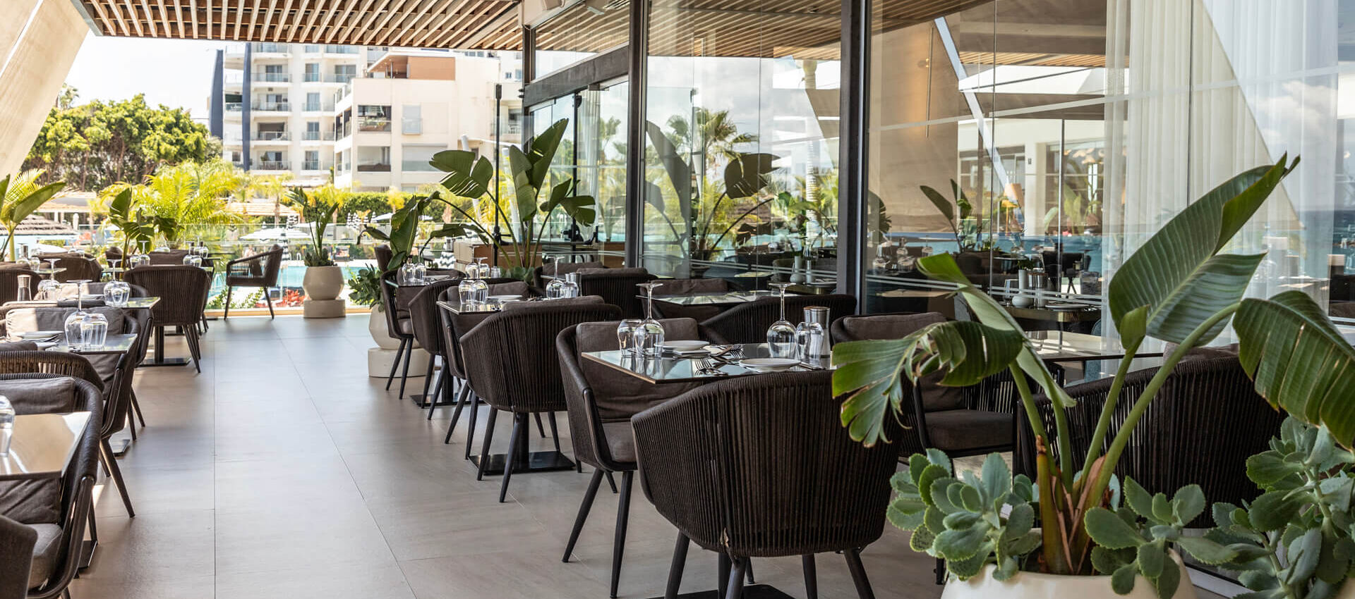Outdoor tables with pool view at Royal Apollonia restaurant
