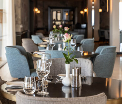 Indoor tables with a rose and prepared for dinner at Royal Apollonia restaurant