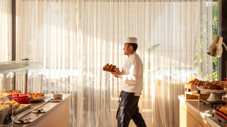 Chef walking with pastries at Royal Apollonia restaurant buffet