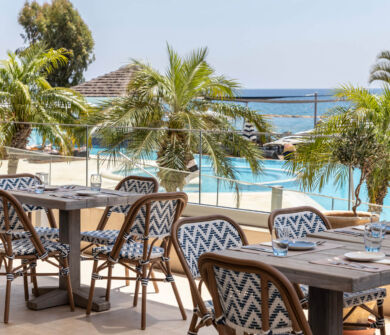 Outdoor tables with pool view at Royal Apollonia restaurant