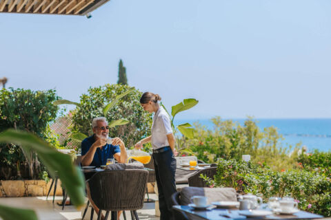 Man getting served at oustide tables at Royal Apollonia resort