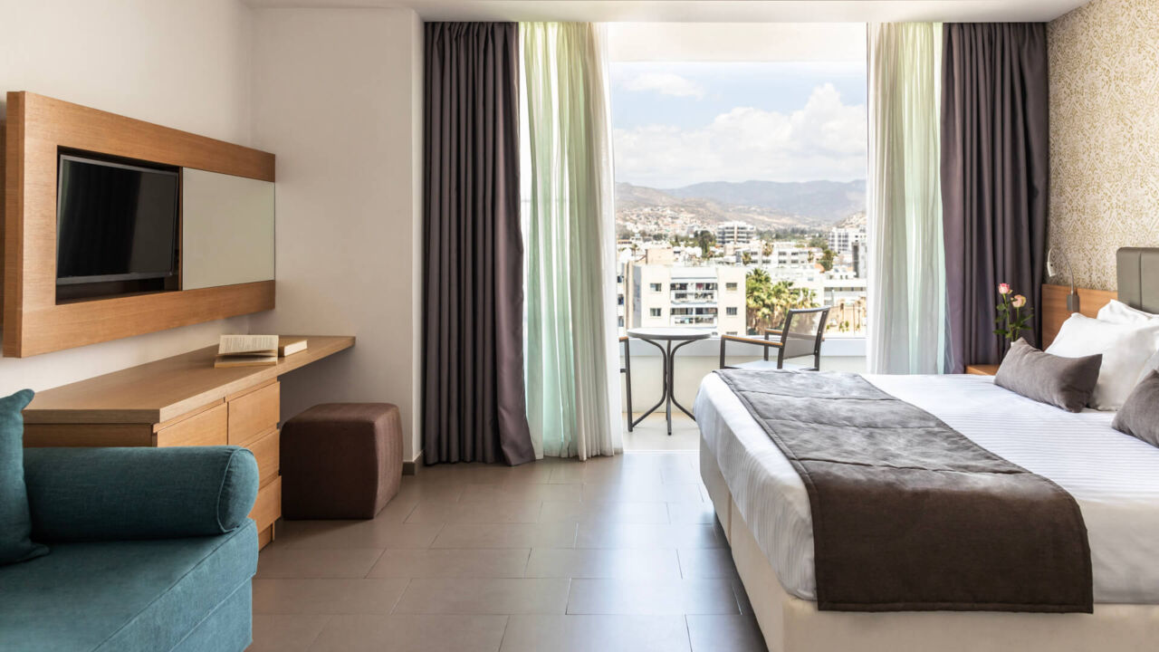 Royal Apollonia Family room bedroom and sitting area with balcony with city view