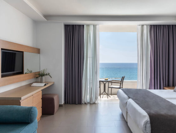 Royal Apollonia Family room bedroom and sitting area with balcony with sea view