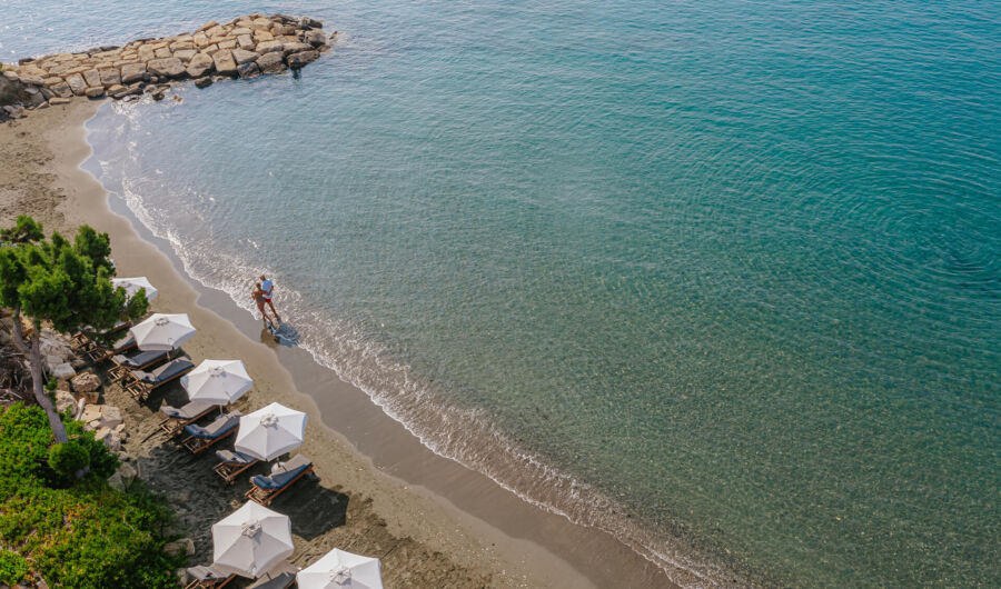 Couple walk at Royal Apollonia beach