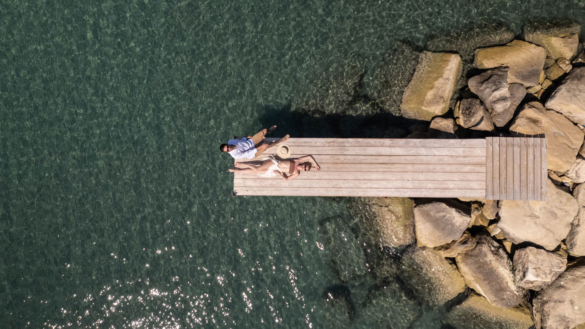 Couple sunbathing at a dock of Royal Apollonia