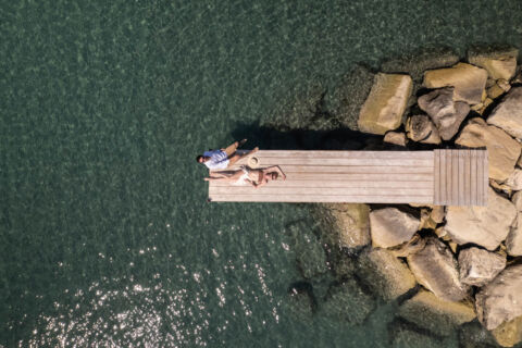 Couple sunbathing at a dock of Royal Apollonia