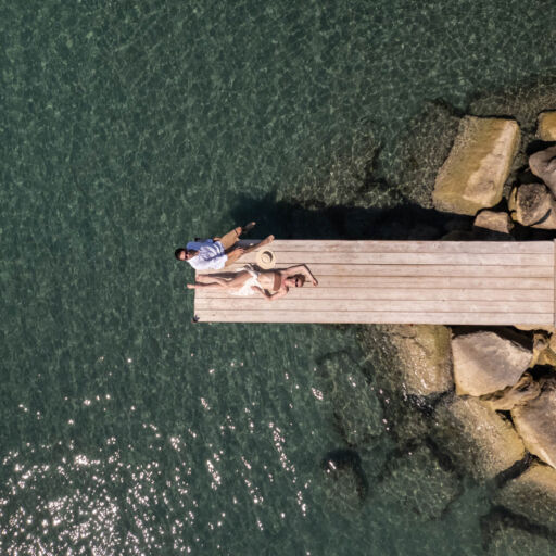 Couple sunbathing at a dock of Royal Apollonia