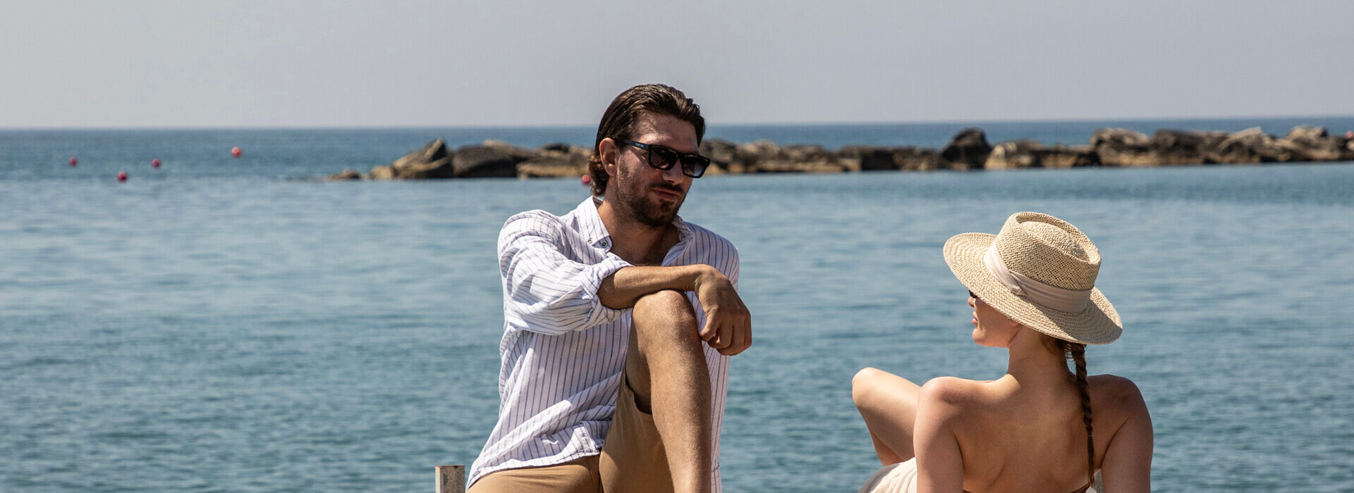 Couple sunbathing and talking near the sea at Royal Apollonia
