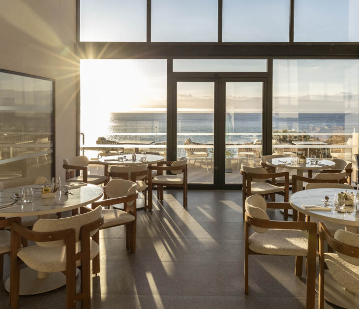 Inside and outside tables prepared for lunch with sunset sea view at Valmar Corfu
