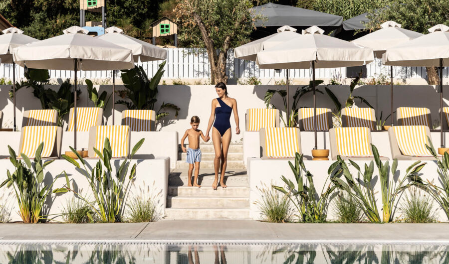 Mother and child walking through Valmar Corfu in swimsuits