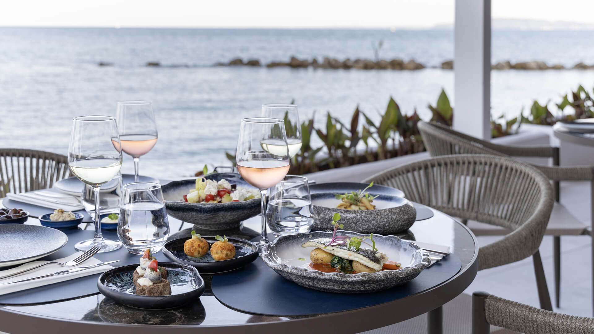 Table with appetizers ,spreads and wine with sea view at Valmar Corfu Gill Restaurant