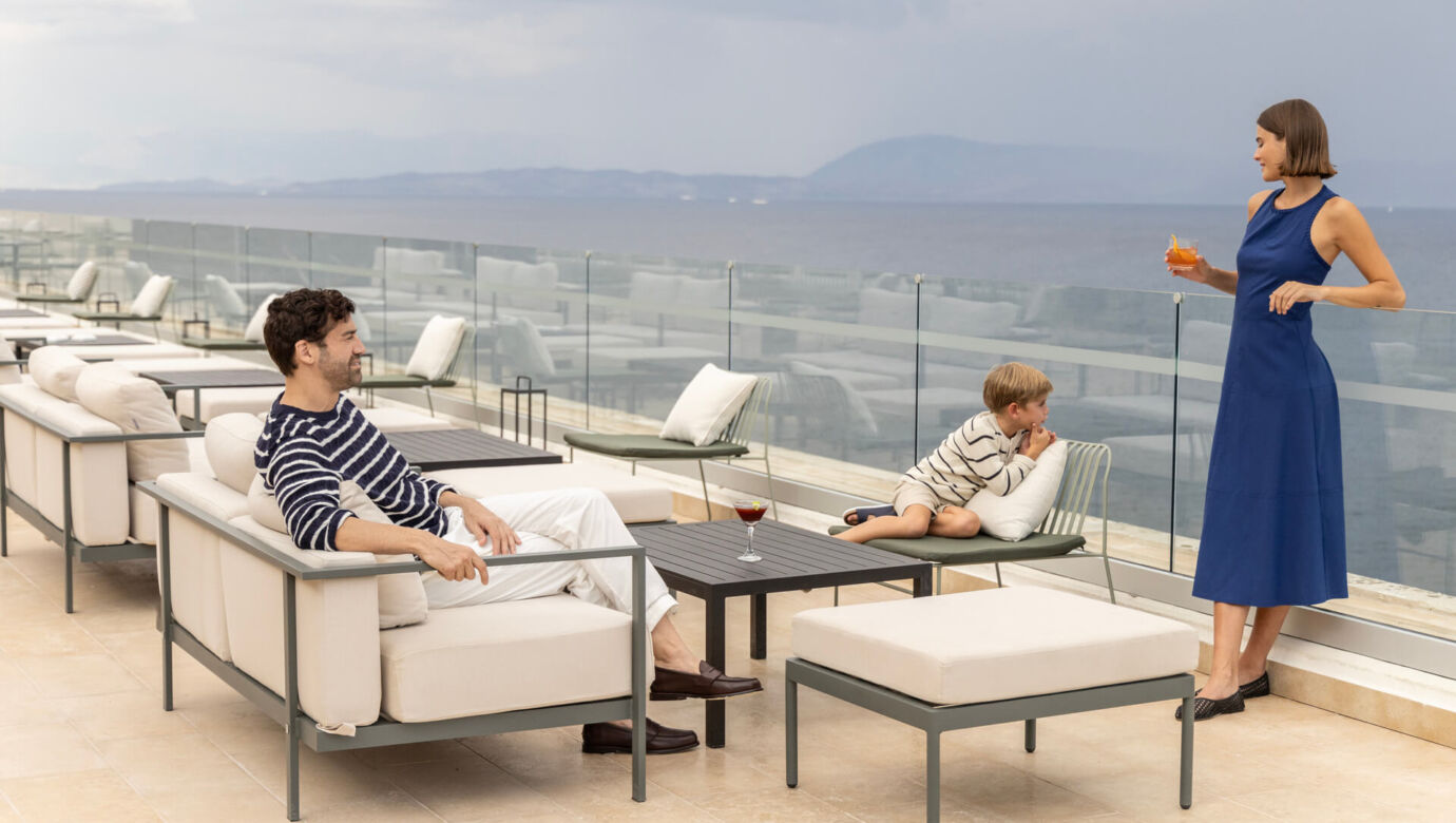 Family relaxing on couches at rooftop restaurant at Valmar Corfu Tarazza