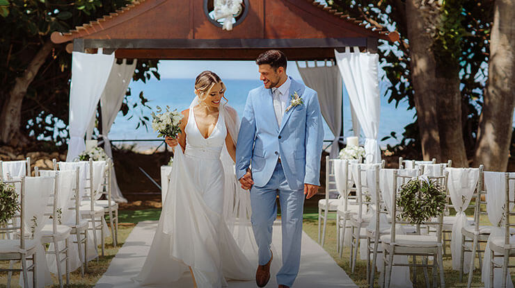 Bride and groom walking at seaside wedding ceremony